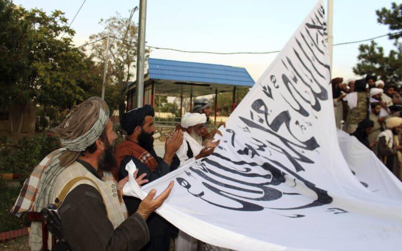 Taliban fighters pray during rising their large flag in Ghazni provincial governor house, southwest of Kabul, Afghanistan, Sunday, Aug. 15, 2021. (AP Photo/Gulabuddin Amiri)