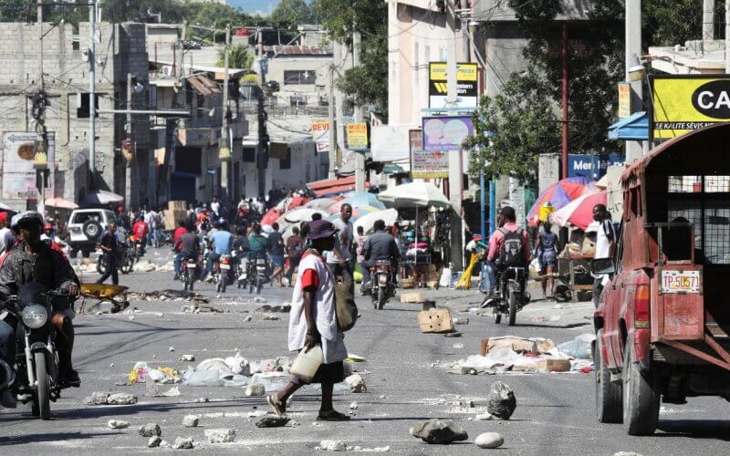 People walk along a street with debris and rocks in Port-au-Prince, Haiti, on Thursday. Reuters