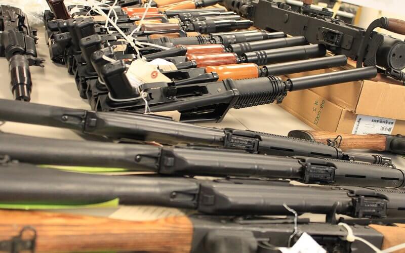 Guns, handguns, AK-47s and .50 caliber rifles, on display during an announcement about arrests and weapons seizures made during Operation Fast and Furious. Shutterstock
