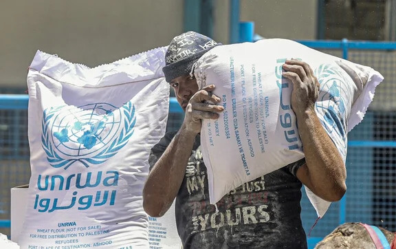 Palestinians receive their monthly food rations from the United Nations Relief and Works Agency (UNRWA) warehouse in Khan Younis in the southern Gaza Strip on June 14, 2022. (Photo by SAID KHATIB / AFP)