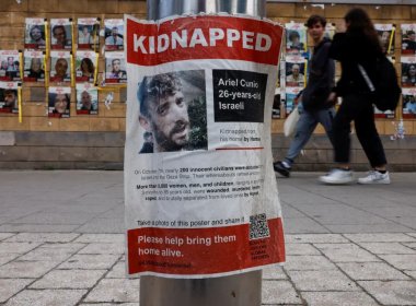 People walk past posters with pictures of hostages kidnapped in the deadly October 7 attack on Israel by the Palestinian Islamist group Hamas from Gaza, in Tel Aviv, Israel March 24, 2024. Reuters
