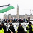A pro-Palestinian protestor waves a Palestinian flag on Wellington St., as pro-Israel protestors rally on Parliament Hill in Ottawa, on Monday, Dec. 4, 2023. The Canadian Press