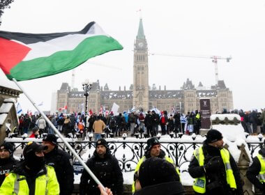 A pro-Palestinian protestor waves a Palestinian flag on Wellington St., as pro-Israel protestors rally on Parliament Hill in Ottawa, on Monday, Dec. 4, 2023. The Canadian Press