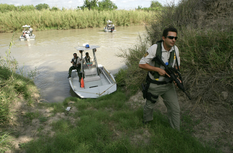 Border Patrol agents inspect a potential landing spot for illegal immigrants along the Rio Grande River in Texas. U.S. Customs and Border Protection