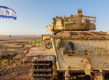 Israeli flag flying beside a decommissioned Israeli Centurion tank used during the Yom Kippur War at Tel Saki on the Golan Heights in Israel. Shutterstock