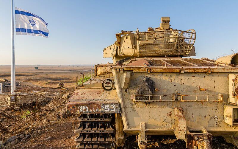 Israeli flag flying beside a decommissioned Israeli Centurion tank used during the Yom Kippur War at Tel Saki on the Golan Heights in Israel. Shutterstock
