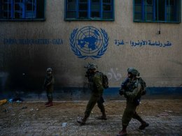 Israeli soldiers take position as they enter the UNRWA headquarters where the military reportedly discovered tunnels underneath the U.N. agency that the military says Hamas militants used to attack its forces during a ground operation in Gaza. AP