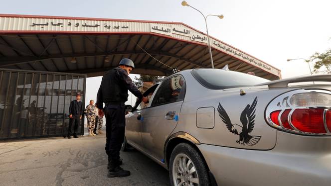 A Jordanian policeman checks a car at Jordan's Jaber border crossing checkpoint near Syria's Nasib checkpoint. Reuters