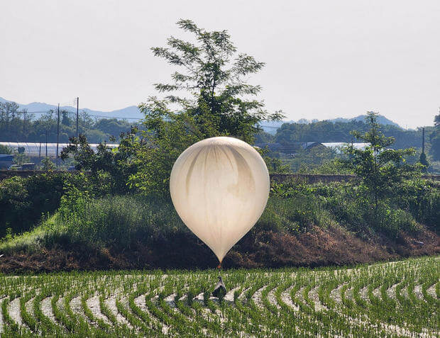 A balloon believed to have been sent by North Korea, carrying various objects including what appeared to be trash and excrement, is seen over a rice field at Cheorwon, South Korea, May 29, 2024. Yonhap