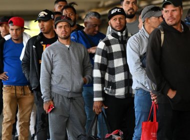 Venezuelan migrants wait in a line to be admitted to shelters at a migrant processing center in Denver, Colorado. Denver Post