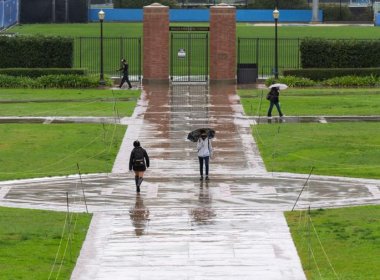 Students walk through Wilson Plaza during a rainy day on campus at the University of California, Los Angeles.