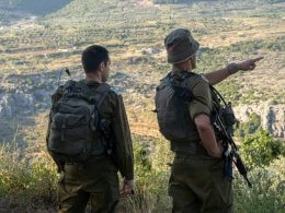 IDF officers watching troops maneuvering through Israel's northern terrain. IDF