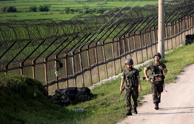 South Korean army soldiers patrol through the military wire fence in Paju. AP