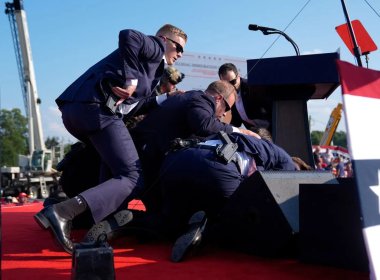 Republican presidential candidate former President Donald Trump is covered by U.S. Secret Service agents at a campaign rally, Saturday, July 13, 2024, in Butler, Pa. (AP Photo/Evan Vucci)