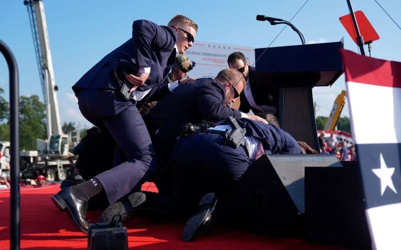 Republican presidential candidate former President Donald Trump is covered by U.S. Secret Service agents at a campaign rally, Saturday, July 13, 2024, in Butler, Pa. (AP Photo/Evan Vucci)