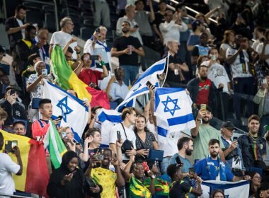 Supporters of Israel and Mali fly their flags at the men's group D soccer match. Olympic Committee of Israel