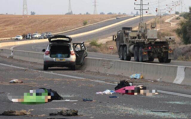 Bodies lie on a main road near Kibbutz Gevim on October 7, 2023 following an attack by Hamas terrorists. AFP