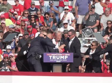 A bloodied former President Donald Trump is lifted from the podium floor after an assassination attempt. facebook.com