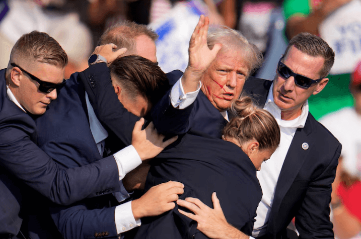 Republican presidential candidate former President Donald Trump is helped off the stage by U.S. Secret Service agents at a campaign event in Butler, Pa., on July 13, 2024.