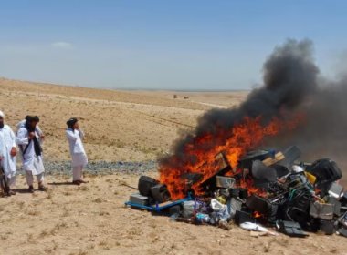 Members of the Taliban morality police stand beside a bonfire of musical instruments and equipment they confiscated and burned in the Western Afghan city of Herat. AFP