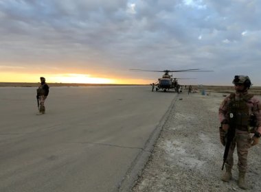 Iraqi security forces are seen at al-Assad airbase near a military helicopter in Anbar province. Reuters