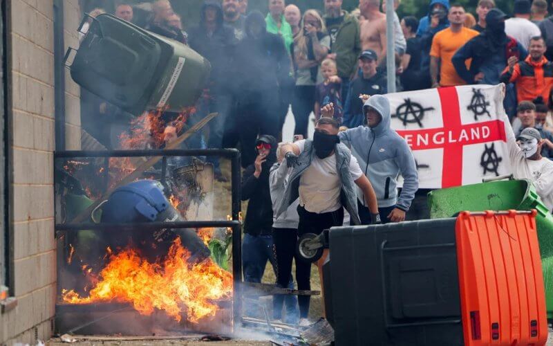 Rioters throw a garbage bin on fire outside a hotel in Rotherham. Reuters