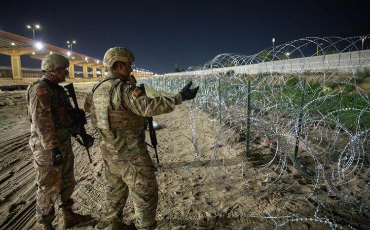 Members of the Texas National Guard erecting razor wire barriers on state land in El Paso, Texas. twitter.com