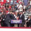 A bloodied former President Donald Trump is lifted from the podium floor after an assassination attempt in Butler, Pa., on Saturday, July 13, 2024. facebook.com