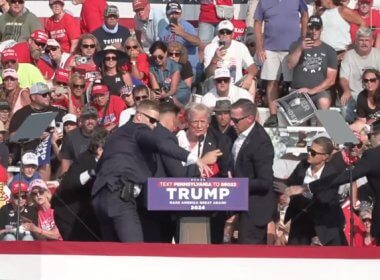 A bloodied former President Donald Trump is lifted from the podium floor after an assassination attempt in Butler, Pa., on Saturday, July 13, 2024. facebook.com