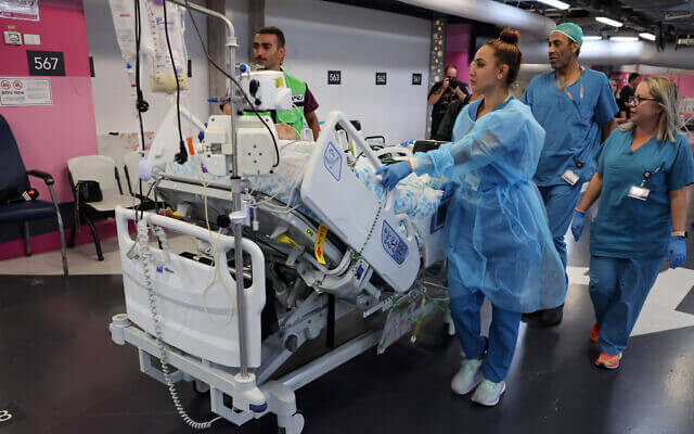 Medical staff at Haifa’s Rambam Medical Center transport a patient from the upper floors after Lebanon’s Hezbollah fired rockets on northern Israel. AFP