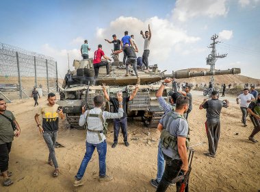 Palestinians take control of an Israeli tank after breaching the Gaza fence, October 7, 2023. Abed Rahim Khatib/Flash90