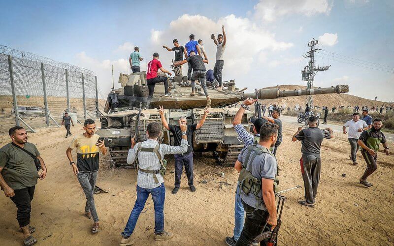 Palestinians take control of an Israeli tank after breaching the Gaza fence, October 7, 2023. Abed Rahim Khatib/Flash90