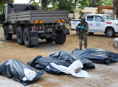 A soldier prepares to remove the bodies of Israelis murdered on October 7, 2023. AFP