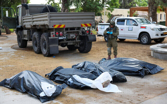 A soldier prepares to remove the bodies of Israelis murdered on October 7, 2023. AFP