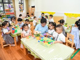 A teacher helps kindergarten pupils in Haikou. VCG