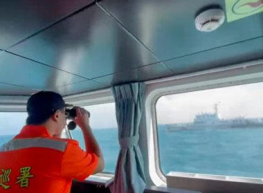 A member of the Taiwan Coast Guard monitors a China Coast Guard vessel. AP