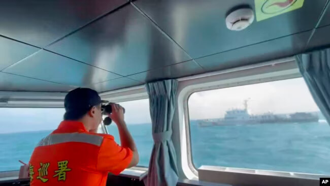 A member of the Taiwan Coast Guard monitors a China Coast Guard vessel. AP