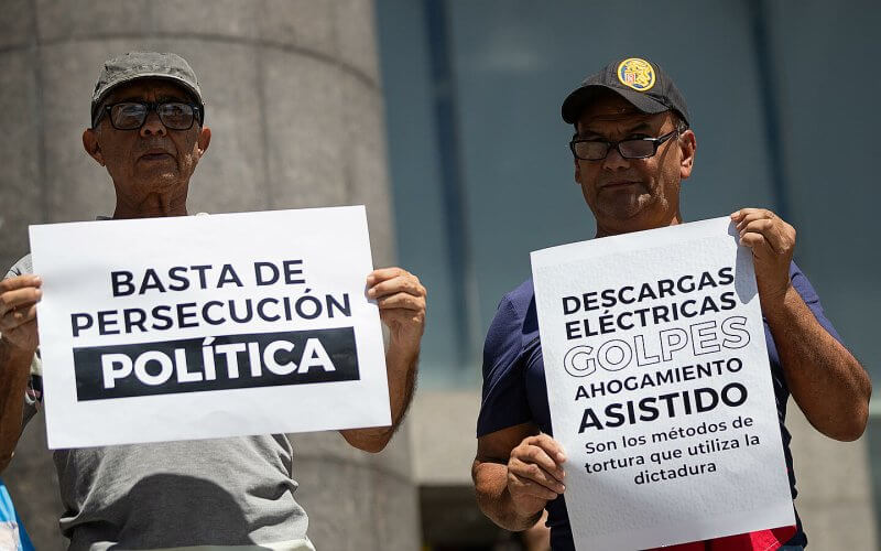 Personas sostienen carteles durante una manifestación frente a la sede de la ONU en Caracas (Venezuela). | EFE/ Ronald Peña R.