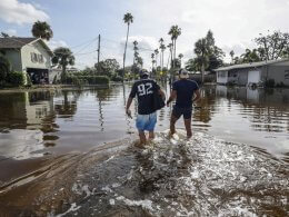 Florida residents walk through floodwaters from Hurricane Helene in Florida. AP