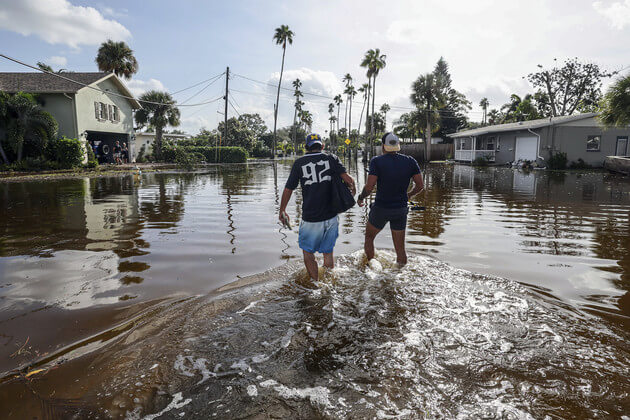 Florida residents walk through floodwaters from Hurricane Helene in Florida. AP