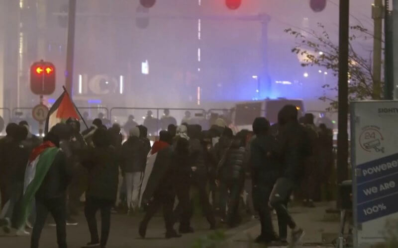 Anti-Israel protesters walk towards a police line in Amsterdam. AP