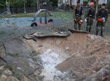 Israeli emergency responders inspect a crater at the site where a projectile fired from Yemen struck in Tel Aviv. AFP