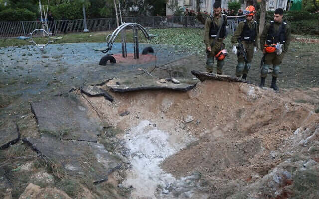 Israeli emergency responders inspect a crater at the site where a projectile fired from Yemen struck in Tel Aviv. AFP