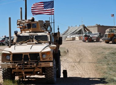 A U.S. soldier sits on an armored vehicle in northern Syria. AP