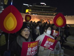 Protesters hold signs reading “Resign Yoon Suk Yeol” in Seoul, South Korea, Dec. 4, 2024. AP