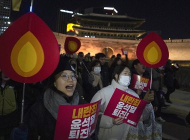 Protesters hold signs reading “Resign Yoon Suk Yeol” in Seoul, South Korea, Dec. 4, 2024. AP