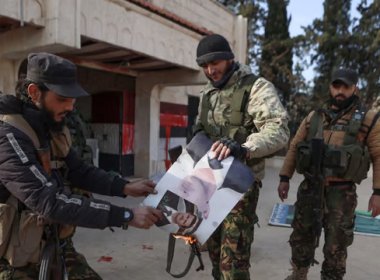 Insurgents set alight a picture of Bashar al-Assad. AFP