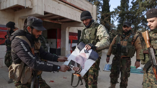 Insurgents set alight a picture of Bashar al-Assad. AFP