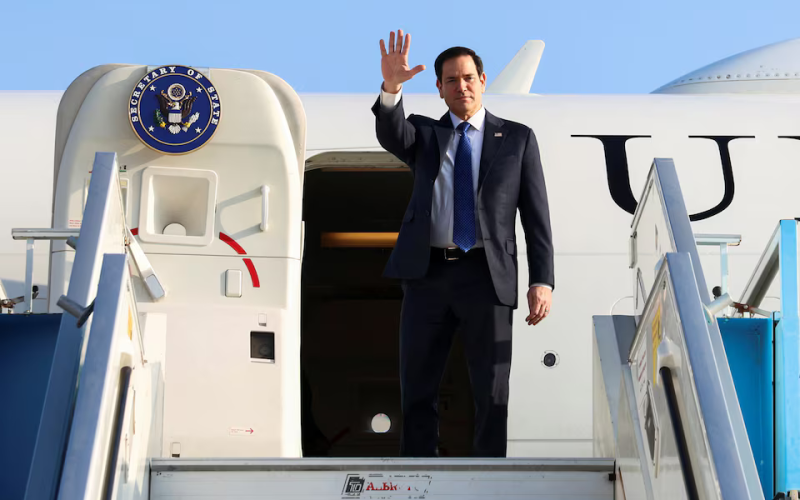 U.S. Secretary of State Marco Rubio waves at reporters as he disembarks from a plane in Tel Aviv.