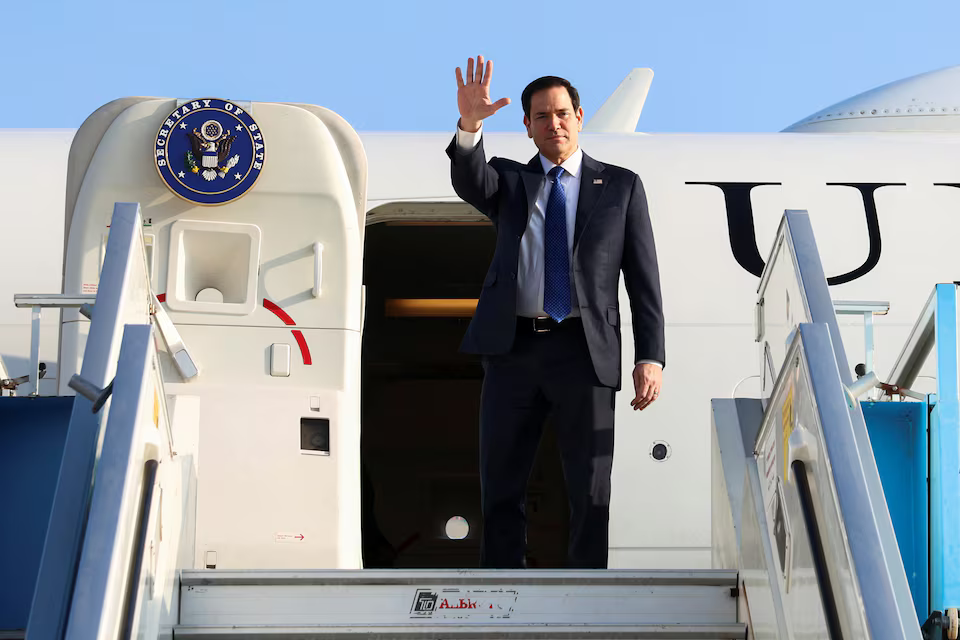 U.S. Secretary of State Marco Rubio waves at reporters as he disembarks from a plane in Tel Aviv.